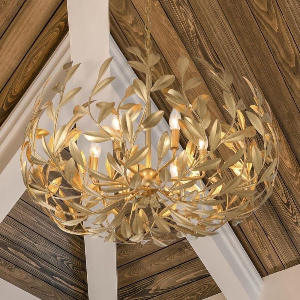 candle style chandelier with gold finish hanging from wooden beams